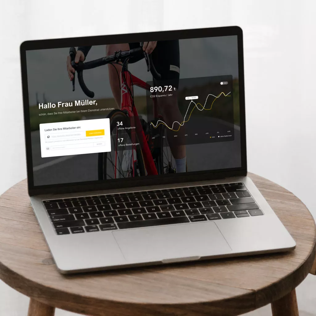 Laptop auf einem Holztisch, der ein Dashboard anzeigt, einschließlich Daten zur CO2-Einsparung, offenen Angeboten und Bestellungen.